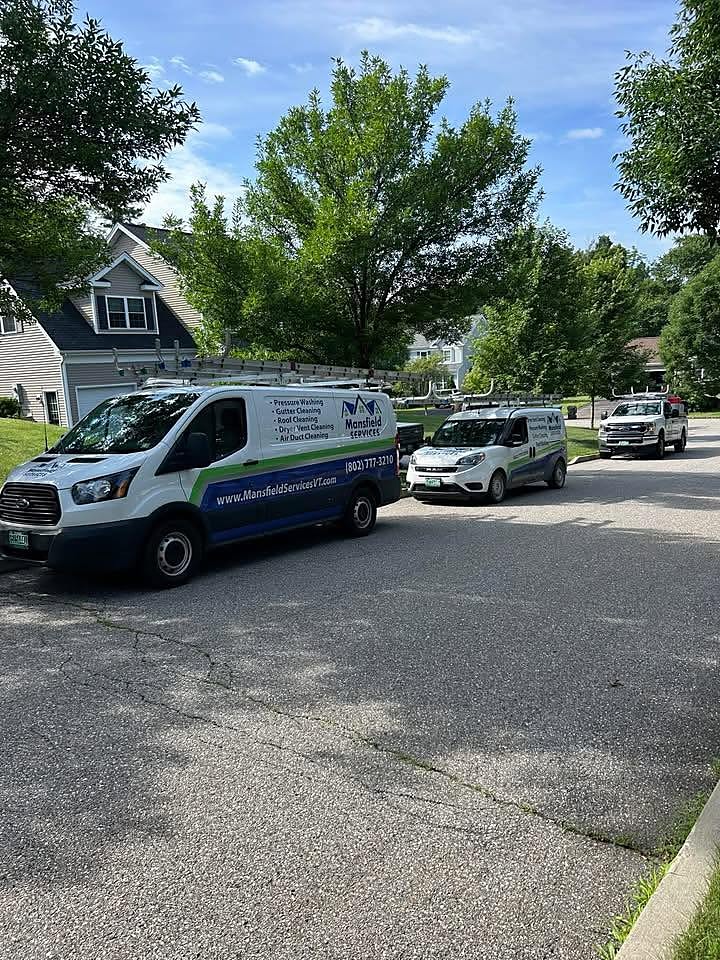 Mansfield Services fleet of vans and trucks in a Vermont neighborhood